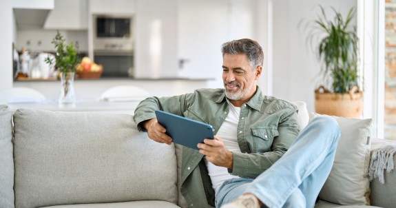 Mann auf Sofa am Tablet