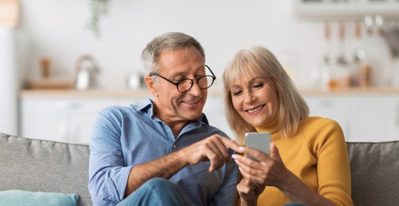 Paar zusammen am Handy auf Sofa