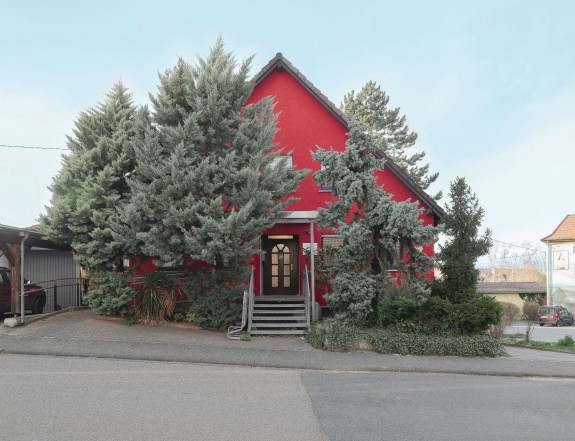 Rotes Haus zwischen Bäumen