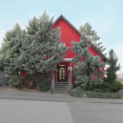 Rotes Haus zwischen Bäumen