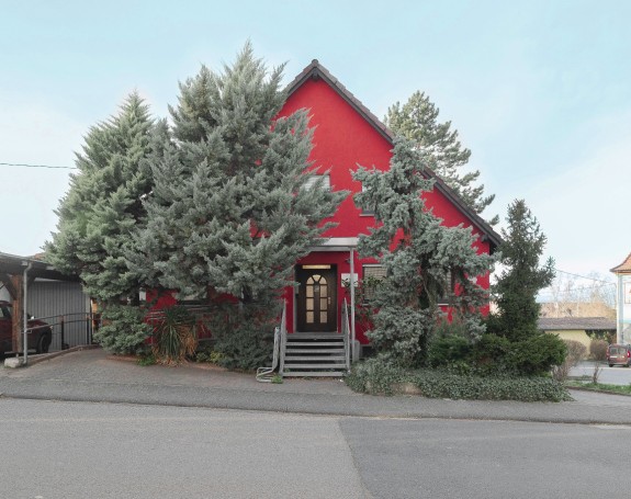 Rotes Haus zwischen Bäumen