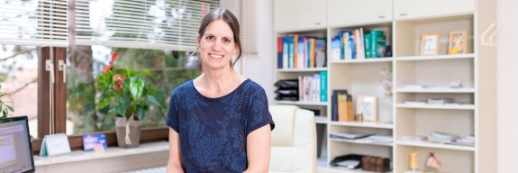 Ärztin sitzt auf Tischkante